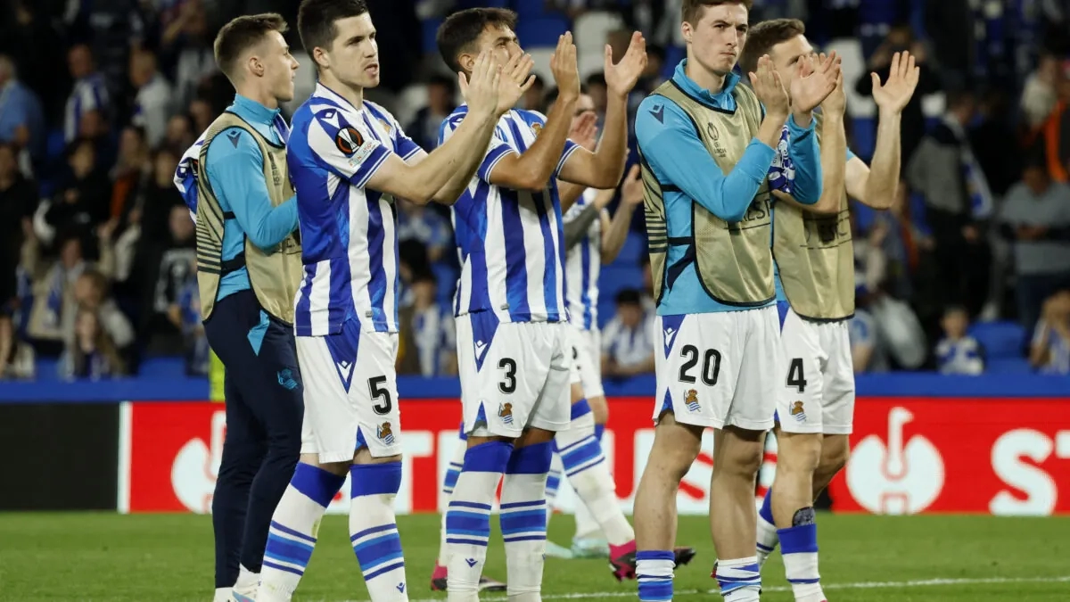 Real Sociedad players applaud the fans.